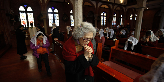Woman prays during Mass at a Catholic church in Seoul