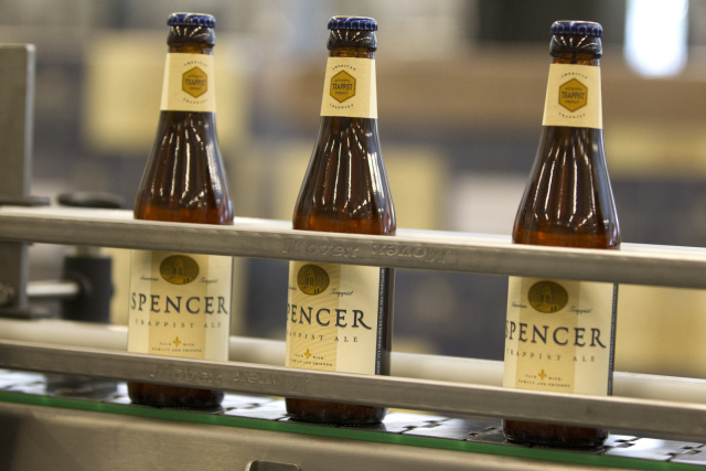 Bottles of beer brewed by Trappist monks sit on conveyer belt at brewery in Spencer, Mass.