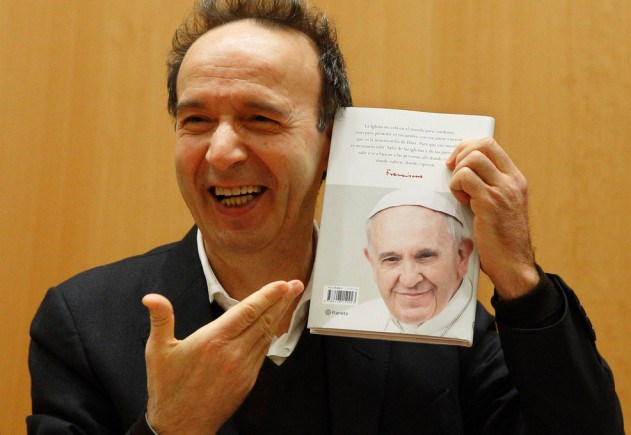 Italian actor Roberto Benigni holds a copy of the book, "The Name of God Is Mercy," during its presentation to journalists in Rome Jan. 12. The book is compiled from an interview Pope Francis did with Italian journalist Andrea Tornielli. (CNS photo/Paul Haring) See POPE-MERCY-BOOK Jan. 12, 2016.